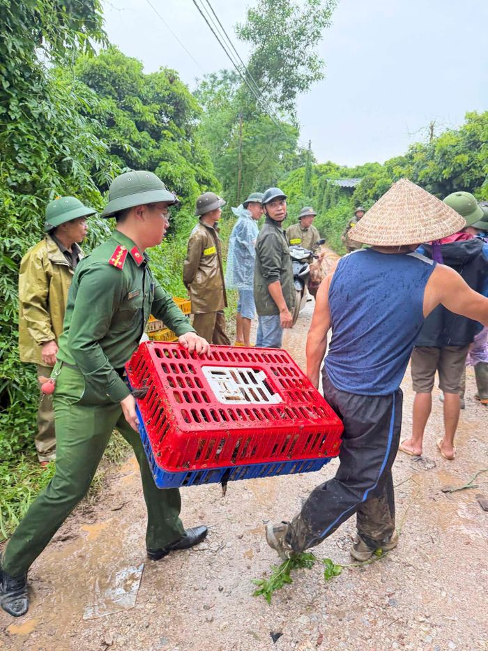 Lực lượng chức năng hỗ trợ người dân di dời tài sản đến nơi an toàn trước nguy cơ nước lũ dâng cao. Ảnh: B.K