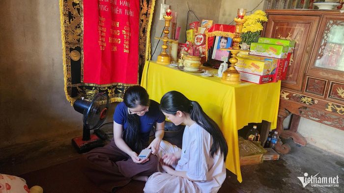 Hai chị em Nhi bên bàn thờ mẹ. Mẹ vừa qua đời, trong nhà còn cha liệt giường và bà nội mù lòa cần người chăm sóc.