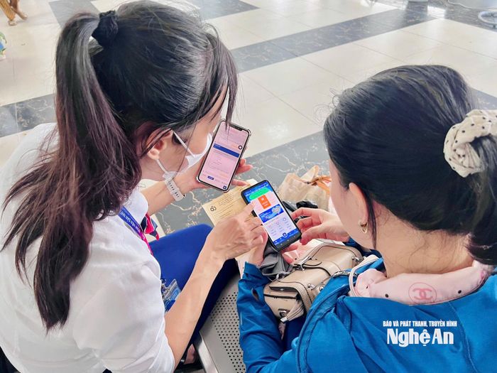 Cán bộ chăm sóc khách hàng hướng dẫn người nhà bệnh nhân cài đặt, sử dụng app "BV San Nhi Nghe An" để nhận, lưu giữ kết quả khám bệnh của trẻ.