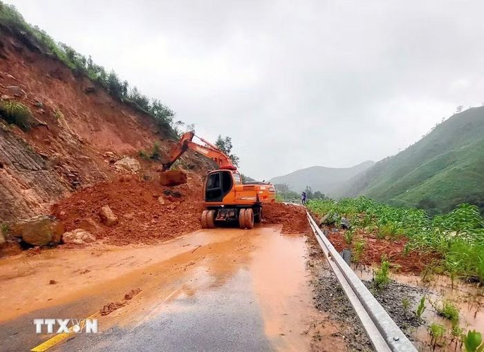 Lực lượng chức năng xã Ba Chẽ thu dọn đất đá sạt lở. (Ảnh: Phạm Lợi/TTXVN)