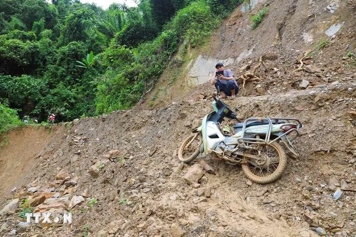 Người dân không thể di chuyển tại điểm sụt trượt tại dốc Có Ngóa trên con đường độc đạo Xốp Kho-Na Ngân (xã Nga My, Nghệ An). (Ảnh: Xuân Tiến/TTXVN)