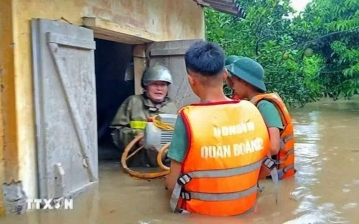 Cán bộ, chiến sỹ Sư đoàn 325 hỗ trợ nhân dân trên địa bàn phường Chũ. (Ảnh: Danh Lam/TTXVN)