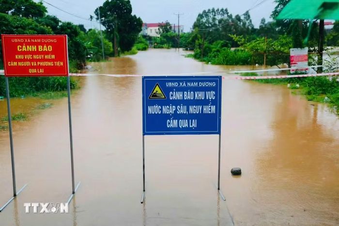 Lực lượng chức năng đặt biển cảnh báo tại các khu vực bị ngập, chia cắt do nước lũ. (Ảnh: Đồng Thúy/TTXVN)
