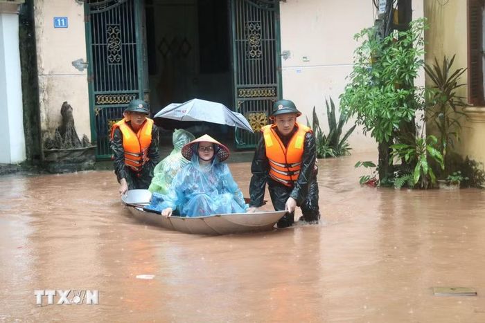 Cán bộ, chiến sĩ Bộ Chỉ huy Quân sự tỉnh Lạng Sơn hỗ trợ người dân vùng ngập lụt Phố Muối, phường Tam Thanh. (Ảnh: Quang Duy.TTXVN)