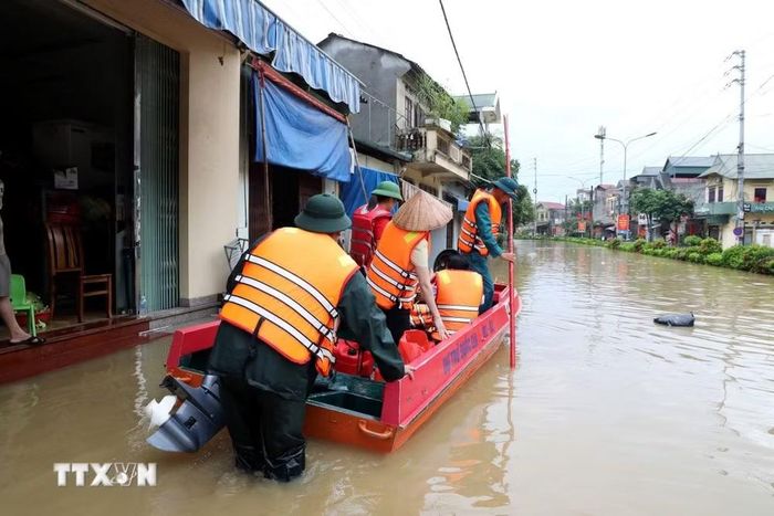 Xã Thất Khê, tỉnh Lạng Sơn bị ngập sâu với gần 1.000 hộ dân bị ảnh hưởng nhà ở, chủ yếu là ngập nước nên người dân và lực lượng chức năng phải di chuyển bằng thuyền trên Quốc lộ 4A qua địa bàn xã. (Ảnh: Văn Đạt/TTXVN)