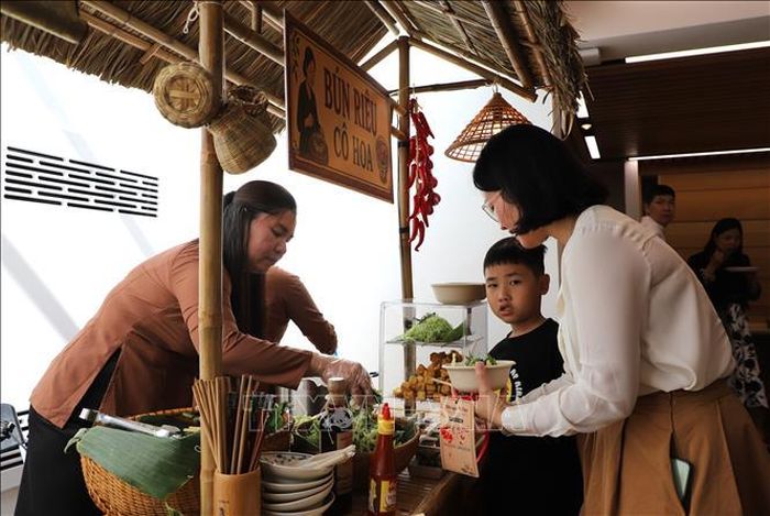 Kiều bào thưởng thức món bún riêu Cô Hoa. Ảnh: Hữu Tiến/TTXVN
