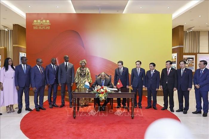 Chủ tịch Quốc hội Cộng hòa Côte d’Ivoire Patrick Achi ký sổ lưu niệm. Ảnh: Doãn Tấn/TTXVN