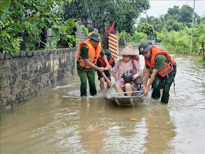 Lực lượng công an tỉnh Bắc Ninh hỗ trợ người dân di dời khỏi vùng lụt. Ảnh: Danh Lam/TTXVN