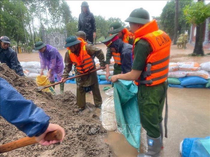 Lực lượng công an tỉnh Bắc Ninh hỗ trợ người dân chống lụt. Ảnh: Danh Lam/TTXVN