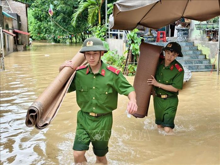 Lực lượng công an tỉnh Bắc Ninh hỗ trợ người dân di dời tài sản. Ảnh: Danh Lam/TTXVN