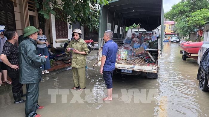 Lực lượng vũ trang phối hợp cùng chính quyền phường Tam Thanh tiến hành tiếp tế nhu yếu phẩm cho nhân dân vùng ngập lụt. Ảnh: Quang Duy – TTXVN