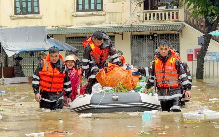 Cán bộ, chiến sĩ Phòng Cảnh sát cơ động hỗ trợ người dân di chuyển tài sản khỏi khu vực ngập lụt