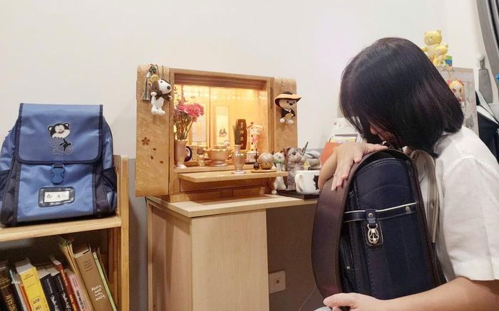 Chị Huỳnh Thị Anh Thư, mẹ ruột của bé Yukiji, bên các di vật của con trai. Ảnh: Gia đình cung cấp
