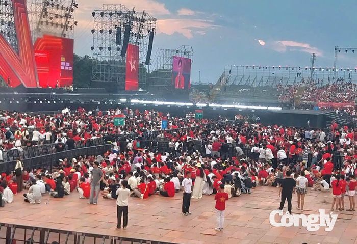 Để có vị trí thuận lợi, nhiều người chủ động đến từ sớm, ai nấy đều háo hức, chụp ảnh lưu niệm và hòa chung sắc đỏ của chương trình.