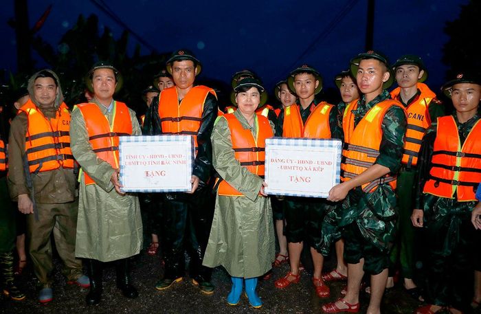 Phó Chủ tịch Thường trực HĐND tỉnh Trần Thị Hằng và Phó Chủ tịch UBND tỉnh Lê Xuân Lợi tặng quà động viên các lực lượng tham gia phòng, chống mưa lũ của xã Kép.