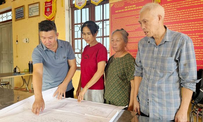 Cán bộ, người dân thôn Trại Quan, xã Đông Phú tìm thông tin thửa đất trên bản đồ.