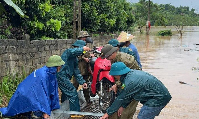  Công an xã Lục Ngạn sử dụng thuyền giúp người dân thôn Thống Nhất di chuyển phương tiện và người qua khu vực ngập sâu. 