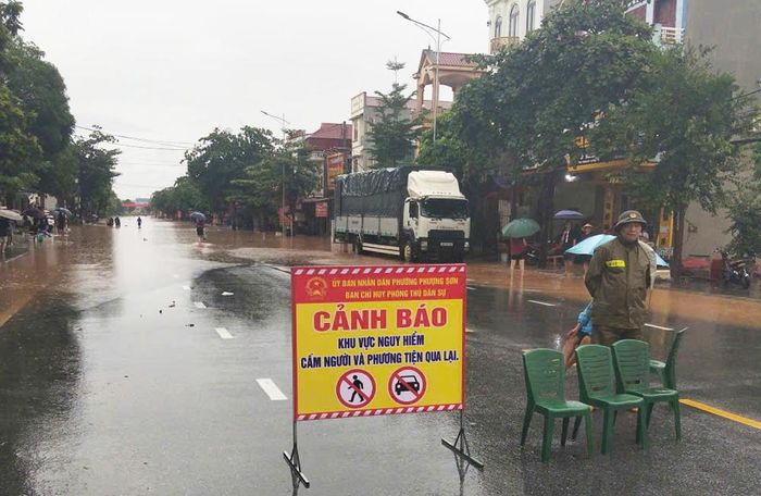 Lực lượng chức năng cắm biển cảnh báo và trực gác tại khu vực nước sâu nguy hiểm trên quốc lộ 31 thuộc phường Phượng Sơn. 