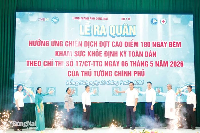 Thứ trưởng Bộ Y tế Đỗ Xuân Tuyên (thứ 4, từ phải qua) cùng các đại biểu thực hiện nghi thức phát động Chiến dịch cao điểm 180 ngày đêm khám sức khỏe định kỳ toàn dân, ngày 12-7 tại phường Trị An. Ảnh: Lê Duy