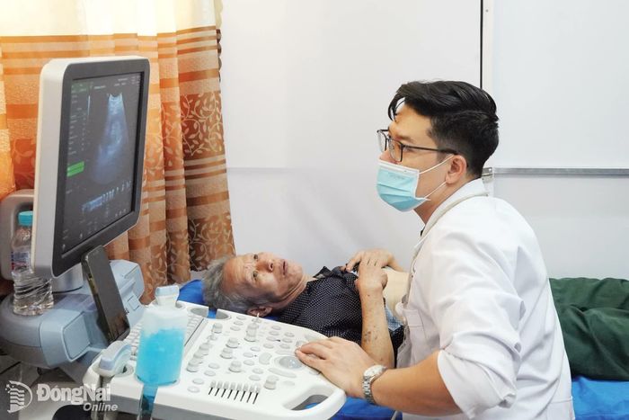 Bác sĩ Phòng khám Đa khoa Tam Phước siêu âm bụng tổng quát cho người cao tuổi trong đợt khám sàng lọc miễn phí ở xã Bình Minh. Ảnh: Bảo Hân