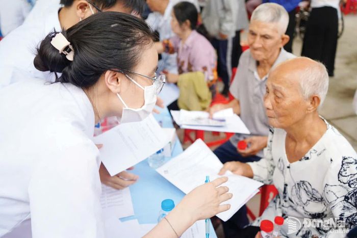 Nhân viên y tế lấy thông tin của người dân ở phường Trị An để cập nhật hồ sơ khám sức khỏe. Ảnh: Lê Duy