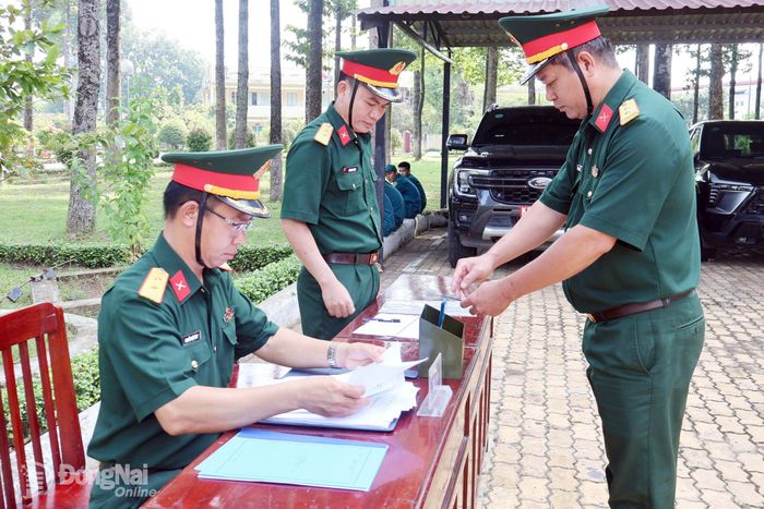 Các đồng chí chính trị viên phó ban chỉ huy quân sự cấp xã tham gia bốc thăm câu hỏi kiểm tra điều lệnh đội ngũ. Ảnh: Nguyệt Hà