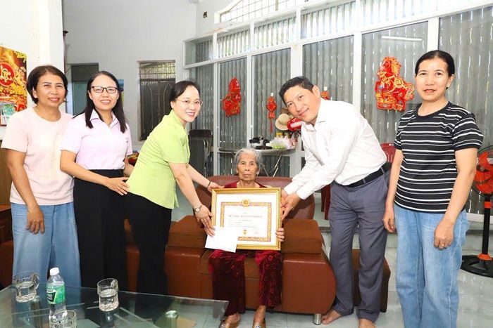 Lãnh đạo Đảng ủy phường trao Huy hiệu 60 năm tuổi Đảng cho đảng viên Lê Thị Kim Quy.