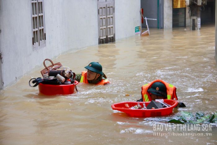Lực lượng chức năng hỗ trợ người dân vùng ngập sâu di dời tài sản đến nơi an toàn