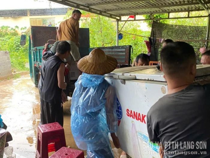 Người dân và lực lượng chức năng hỗ trợ các hộ di dời tài sản