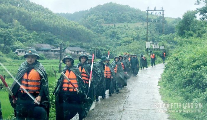 Cán bộ, chiến sĩ thuộc Sư đoàn 3 di chuyển vào khu vực xóm Lũng Do để triển khai công tác hỗ trợ các hộ dân bị ngập do mưa bão