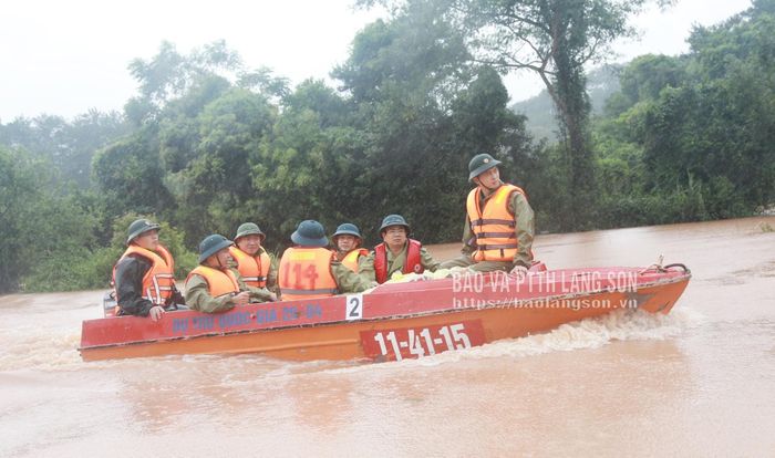 Đoàn công tác di chuyển trên xuồng đến hỗ trợ người dân vùng bị cô lập ở thôn Bản Giểng, xã Mẫu Sơn