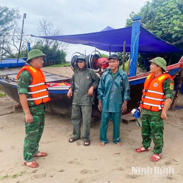 Cán bộ, chiến sĩ Đồn Biên phòng Văn Lý trực tiếp tuyên truyền, nhắc nhở người dân thực hiện các biện pháp bảo đảm an toàn trước diễn biến của bão số 4. Ảnh: CTV