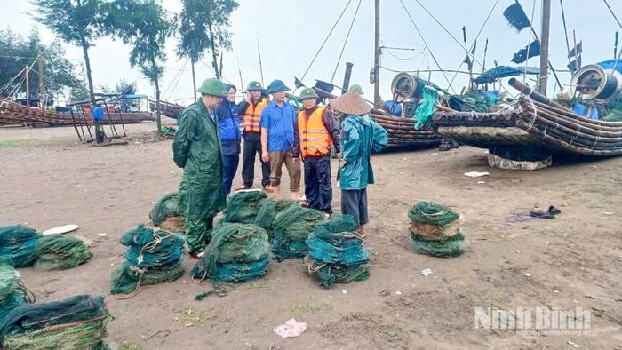 Cán bộ, chiến sĩ Đồn Biên phòng Văn Lý phối hợp với chính quyền địa phương vận động ngư dân thu gom, đưa ngư cụ vào nơi an toàn, chủ động ứng phó với bão số 4. Ảnh: CTV
