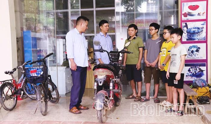 Đảng viên trẻ Nguyễn Văn Linh (đứng thứ hai từ trái sang) tuyên truyền, vận động người dân không giao xe máy điện cho người chưa đủ tuổi, góp phần bảo đảm an toàn giao thông.