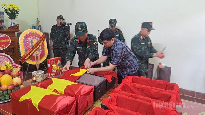 Đại tá Nguyễn Minh Khôi, Phó Chính uỷ BCH QS tỉnh; đồng chí Lý Nam Thuỷ, Bí thư Đảng uỷ xã Minh Tân thực hiện nghi lễ đưa hài cốt liệt sĩ vào áo quan và phủ Cờ Tổ quốc. Ảnh: Fanpage xã Minh Tân