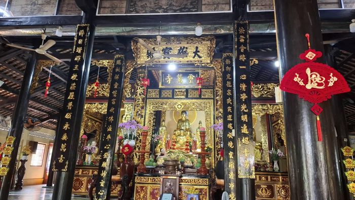 Không gian thờ tự trang nghiêm bên trong chánh điện, nơi những pho tượng, hoành phi và câu đối cùng tạo nên vẻ trầm mặc của cổ tự. Ảnh: Tường Quang