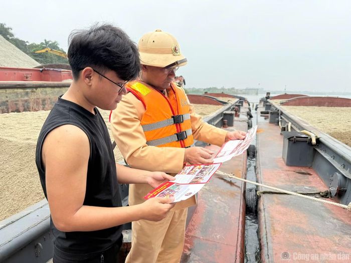 Cán bộ CSGT tuyên truyền, nhắc nhở an toàn đến người dân.