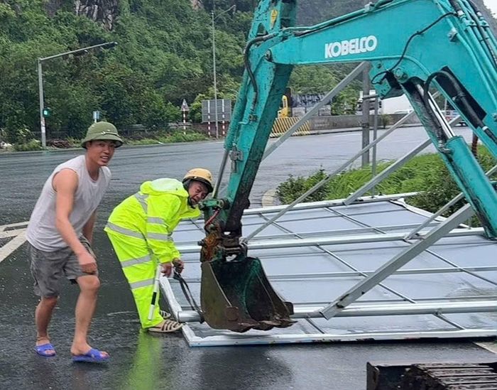 Cảnh sát giao thông Hải Phòng giải tỏa biển quảng cáo lớn bị gió giật đổ để thông đường.
