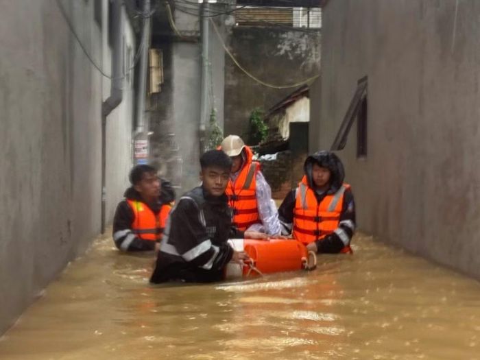 Lực lượng Công an sơ tán người dân khu vực phố Muối ra khỏi khu vực ngập sâu.