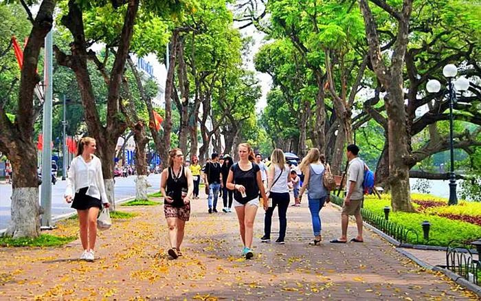 Khách du lịch nước ngoài trải nghiệm hương sắc mùa thu Hà Nội quanh Hồ Gươm. Ảnh: threeland