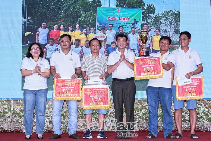 Ông Nguyễn Minh Nhứt, Giám đốc Sở Nội vụ (thứ ba từ phải sang) và bà Trần Yến Hoà, Phó Giám đốc Sở Nội vụ (bìa trái), trao cúp và cờ cùng giải thưởng cho đội bóng đá nam Văn phòng Tỉnh uỷ và các cơ quan tham mưu của Đảng.