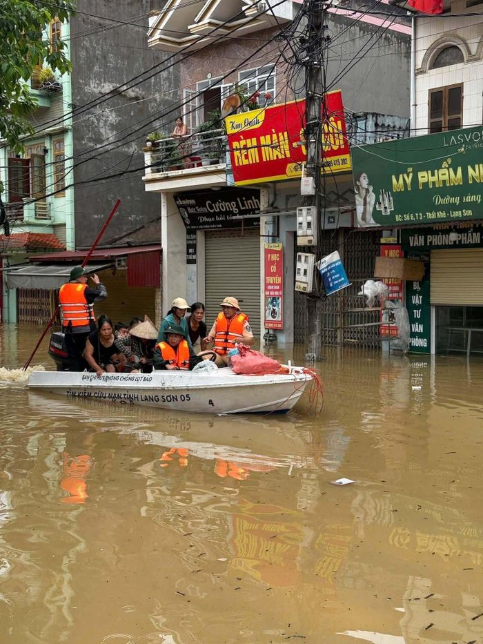 Lực Lượng chức năng đi cano ứng cứu người dân khỏi khu vực ngập sâu.