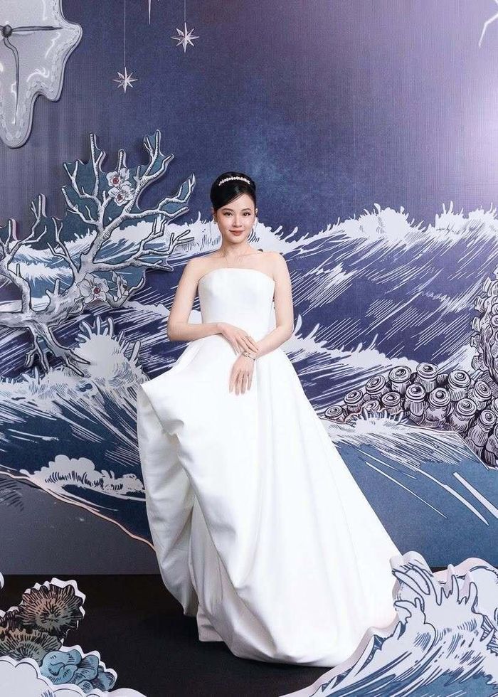 Midu tôn vai trần cùng đầm cúp ngực tông trắng, kết hợp kiểu tóc búi cao khoe trọn visual sang trọng, cổ điển.