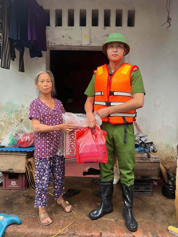 Nước uống, mì gói và lương thực được chuyển đến tay người dân giữa vùng ngập, trong điều kiện đầy khó khăn.