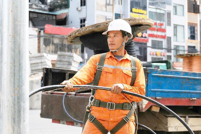 Nhân viên điện lực lắp đặt đường dây cột đèn chiếu sáng.