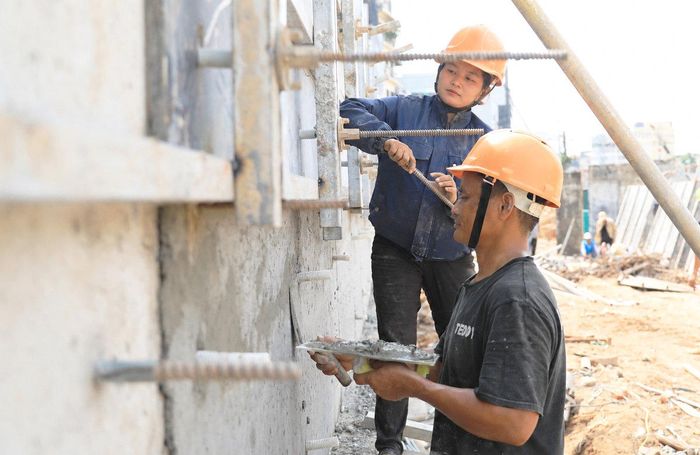Công nhân thi công tường bao và đường dẫn lên đường La Thành.