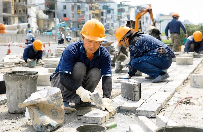 Các công nhân lát đá vỉa hè khu vực từ nút giao Giảng Võ - Láng Hạ đến đường Nguyễn Chí Thanh.