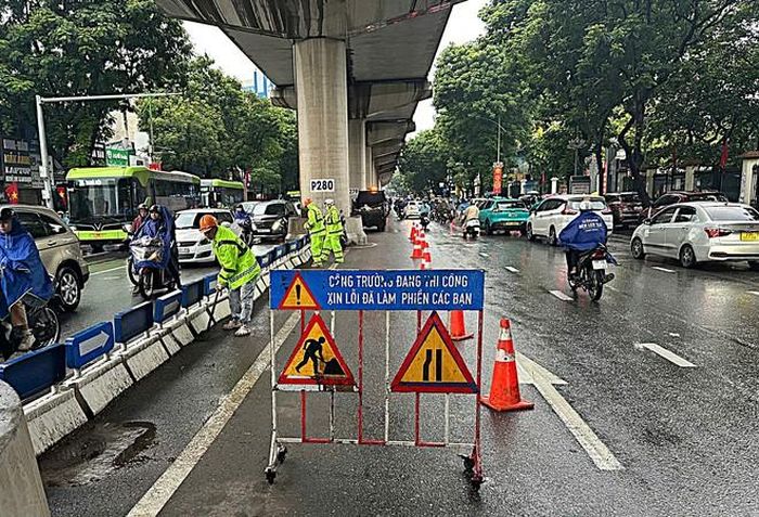 Công nhân thực hiện tổng vệ sinh, dọn dẹp trên các tuyến đường Hà Nội dưới thời tiết mưa kéo dài nhiều ngày do ảnh hưởng của Bão số 4. (Ảnh Thành Long)