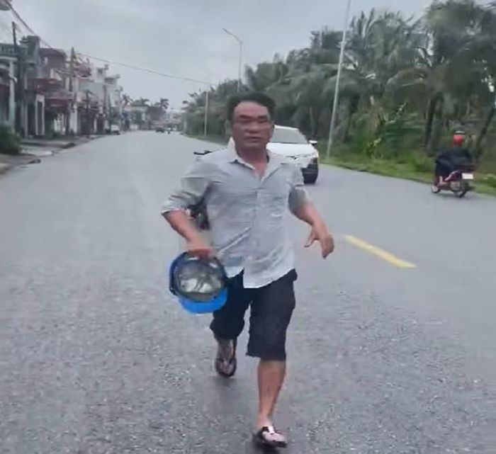Người đàn ông cầm mũ bảo hiểm chạy lại đánh tài xế ô tô. Ảnh: Cắt từ clip.