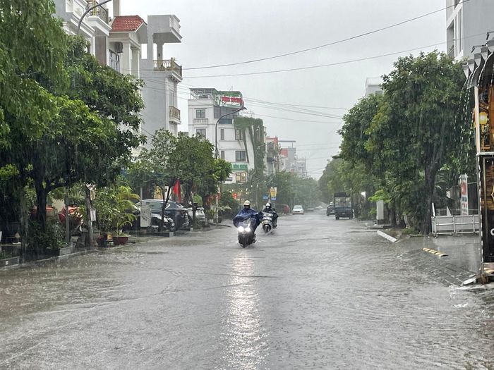 Khu vực gần chợ Lũng (phường Hải An, Hải Phòng) nước dâng cao, lượng mưa lớn gây khó khăn cho người dân trong quá trình di chuyển- Ảnh: TD